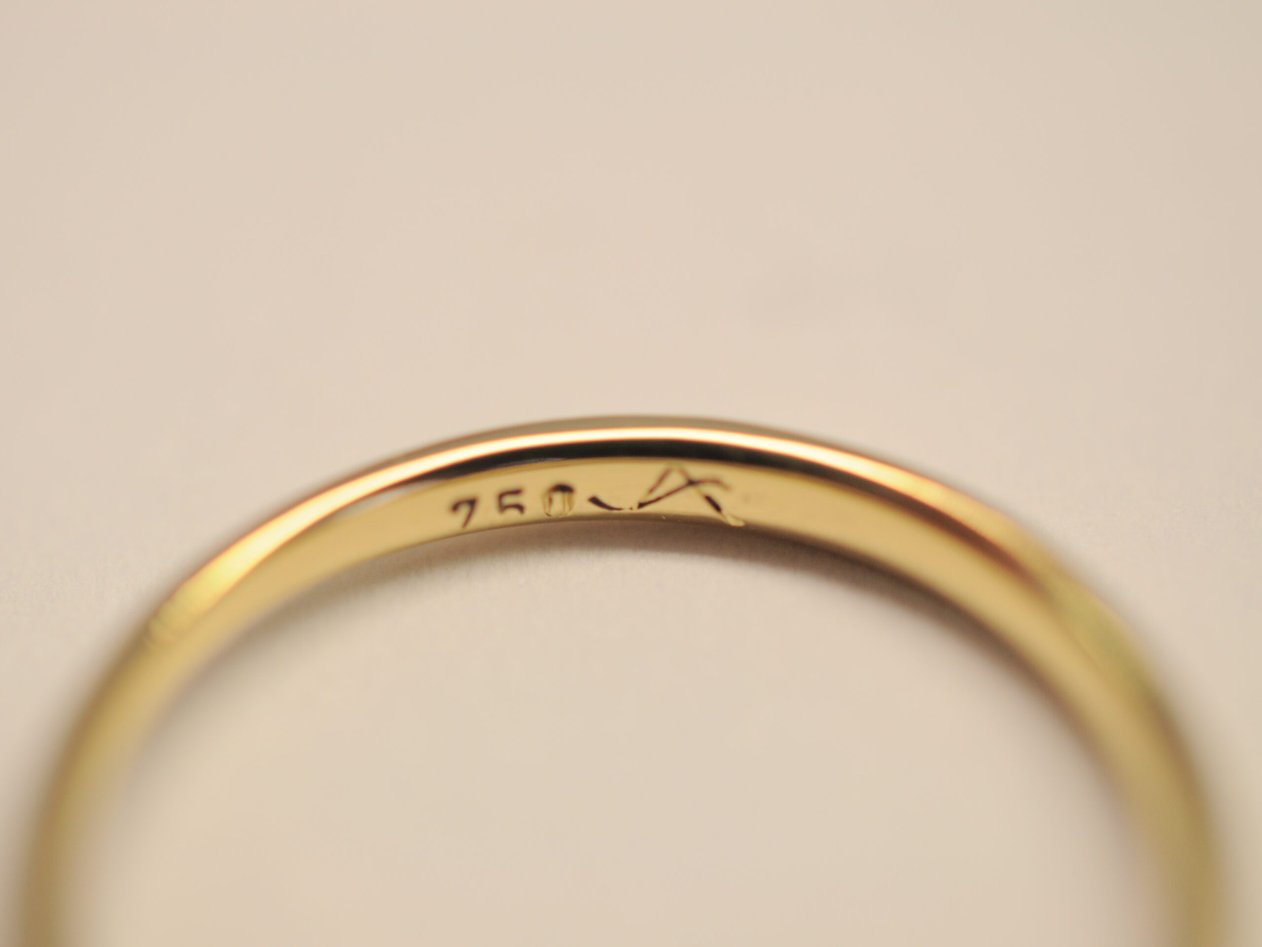 Punzierung des 750er Goldring mit Granat im Treppenschliff